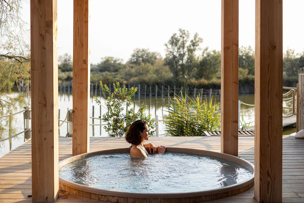 Femme dans un bain à remous faisant face à la nature camarguaise