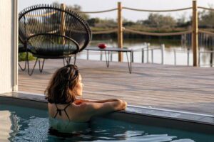 Femme dans une piscine intérieure, regardant au loin vers l'extérieur