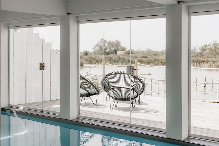 Piscine avec larges baies vitrées donnant sur la nature